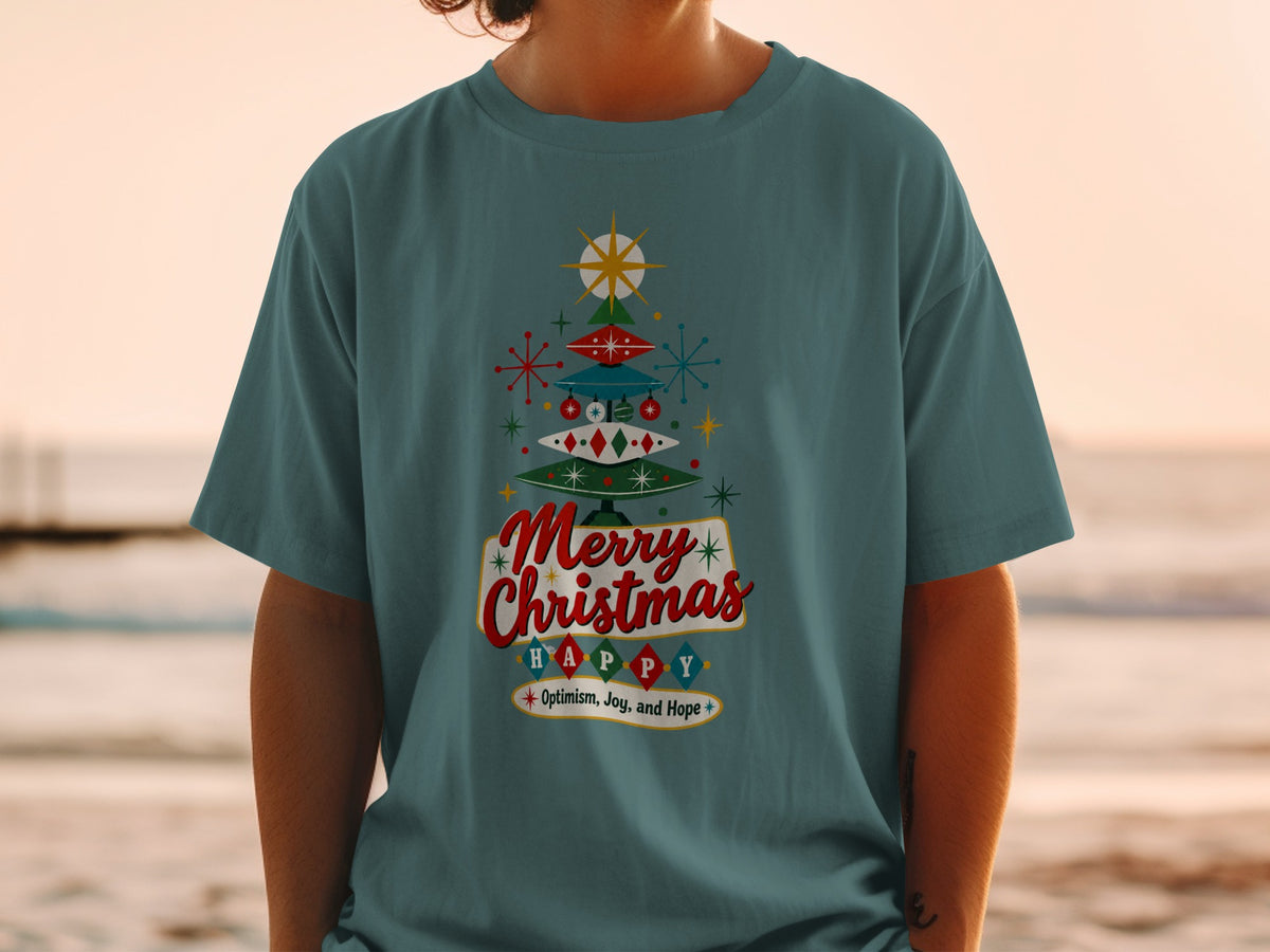 Teal t-shirt with retro Christmas tree graphic reading "Merry Christmas Happy" and "Optimism, Joy, and Hope".