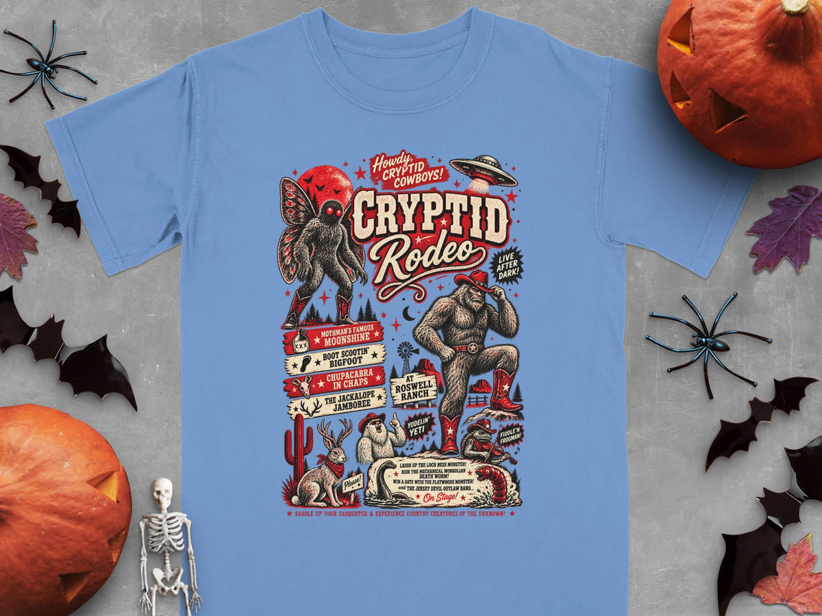 Cryptid Rodeo graphic with Bigfoot, Mothman, Jackalope, and aliens on a light blue shirt.