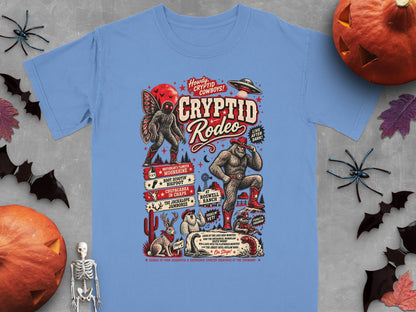 Cryptid Rodeo graphic with Bigfoot, Mothman, Jackalope, and aliens on a light blue shirt.