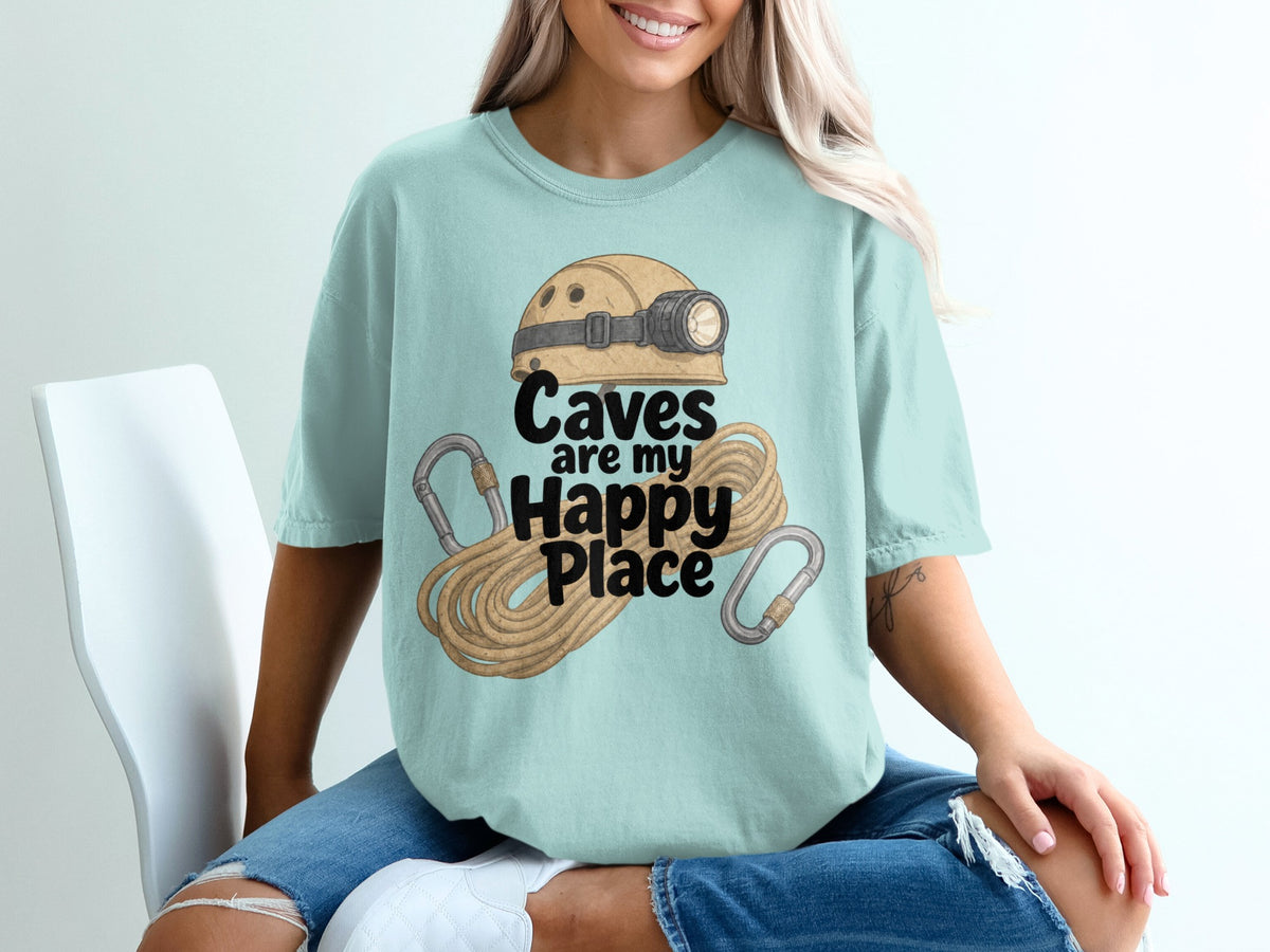 Light blue t-shirt with illustration of caving helmet, rope, and carabiners. Text: Caves are my Happy Place.