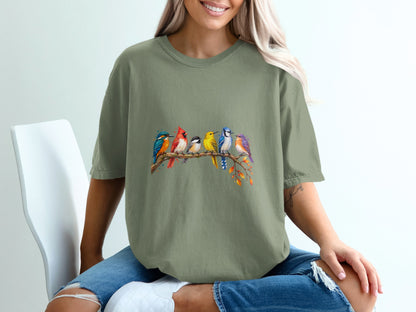 Green t-shirt with watercolor illustration of seven colorful birds perched on a branch.