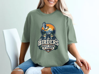 Green t-shirt with "Birders Ready When It Starts" graphic and nature scene.