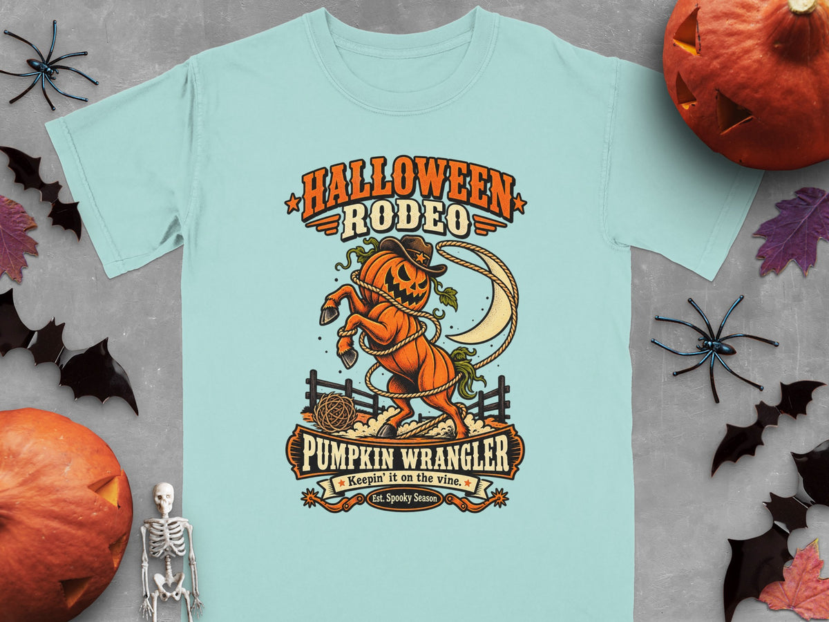 "Halloween Rodeo Pumpkin Wrangler" graphic on a light blue t-shirt.