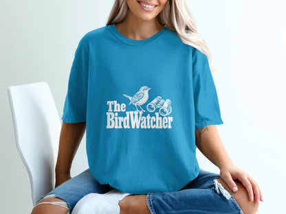 Teal t-shirt with white graphic of a bird and binoculars, text "The BirdWatcher."