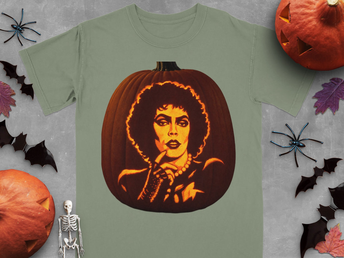 An olive green t-shirt featuring a lit jack-o'-lantern carved with the face of Dr. Frank-N-Furter.