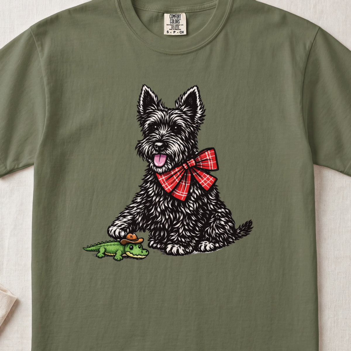 Scottish terrier with a red plaid bow ties next to a crocodile in a cowboy hat.