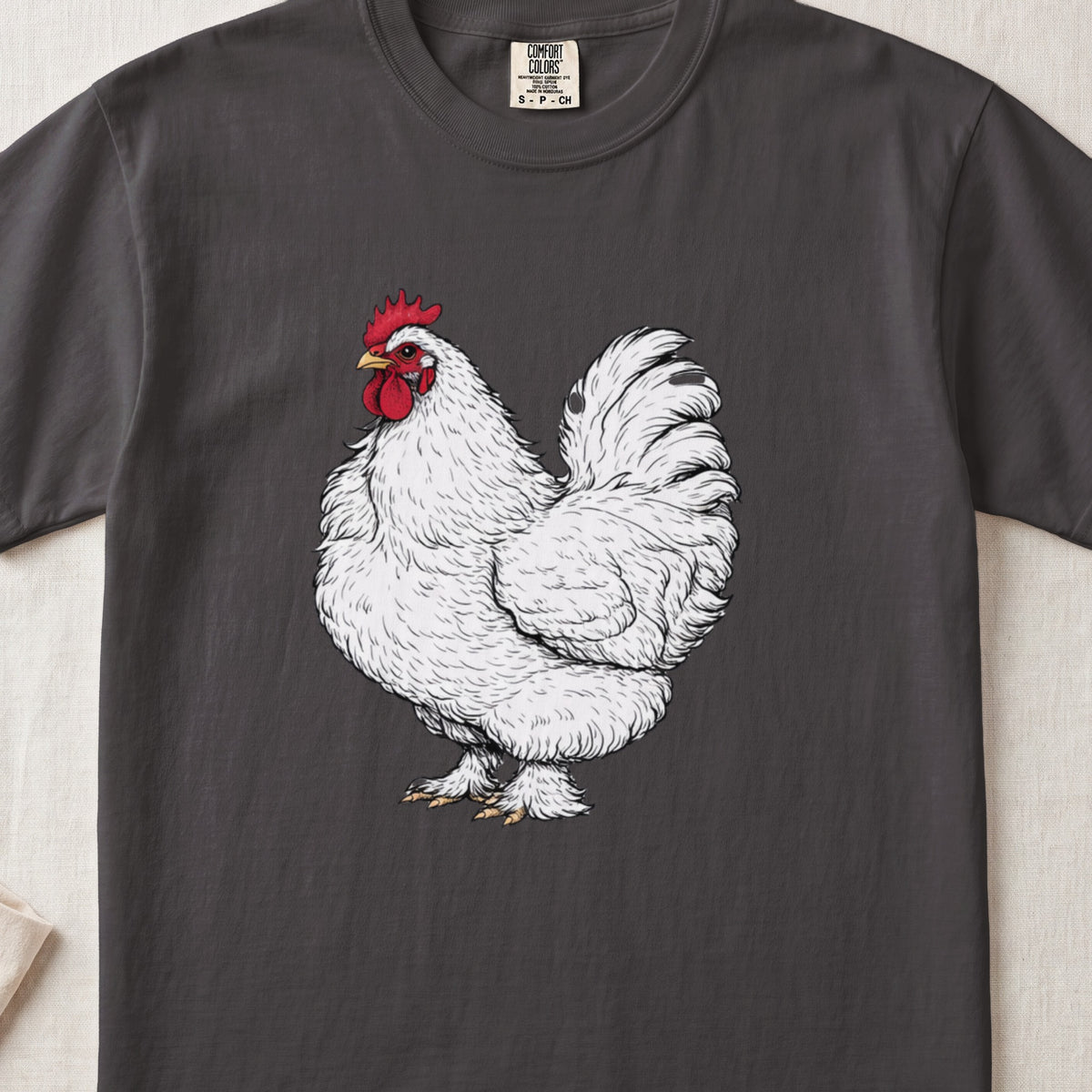 A dark gray t-shirt featuring a detailed illustration of a fluffy white rooster with a red comb.