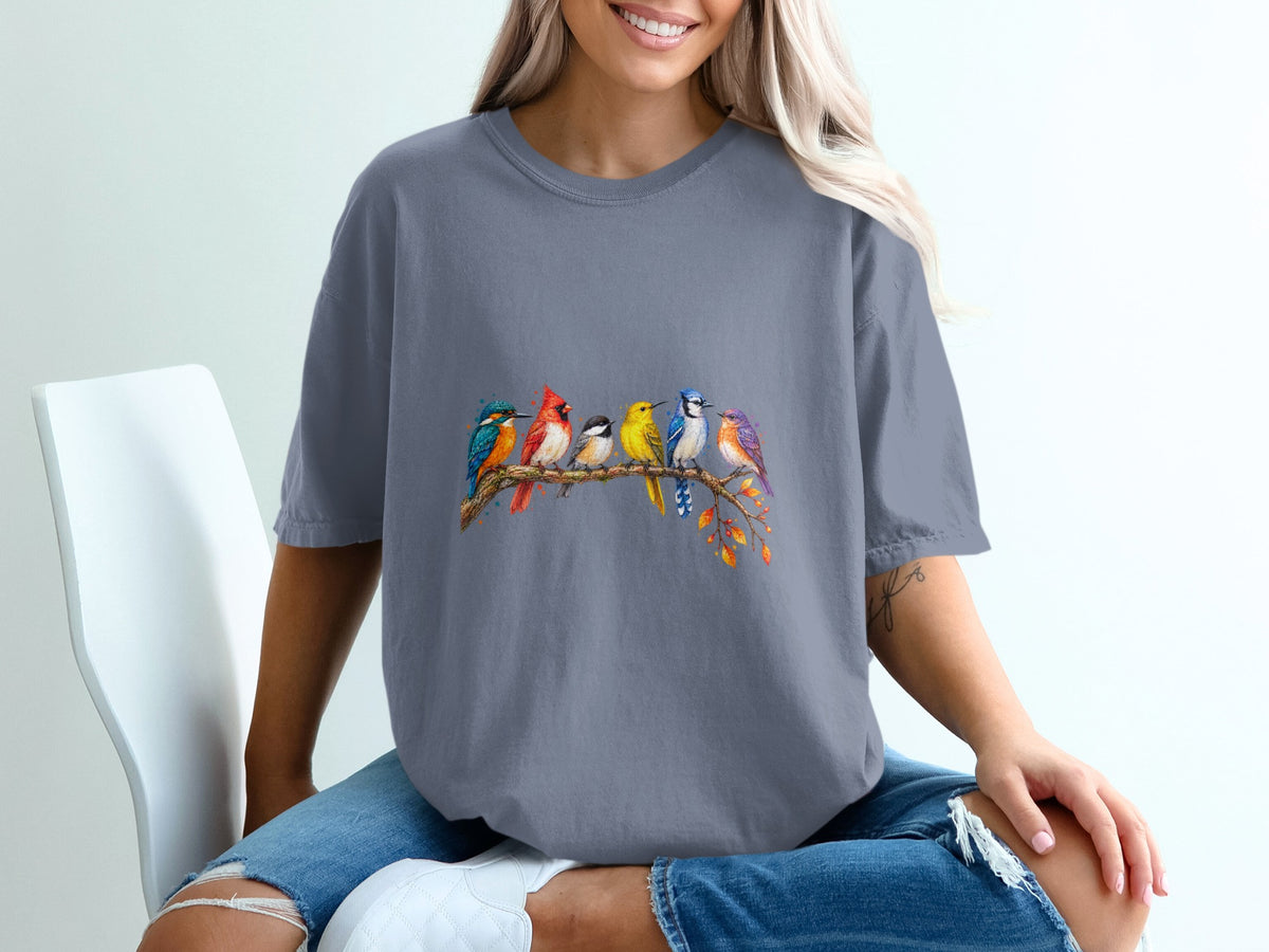 T-shirt features a watercolor print of seven colorful birds perched on a branch.