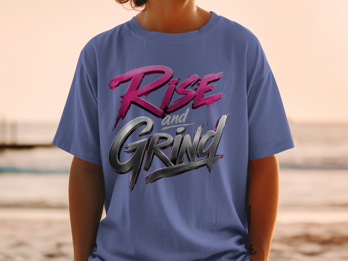 Blue t-shirt with "Rise and Grind" text in metallic pink and silver lettering.