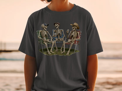 Three skeletons in camping chairs holding drinks with "Bale Ale" visible.