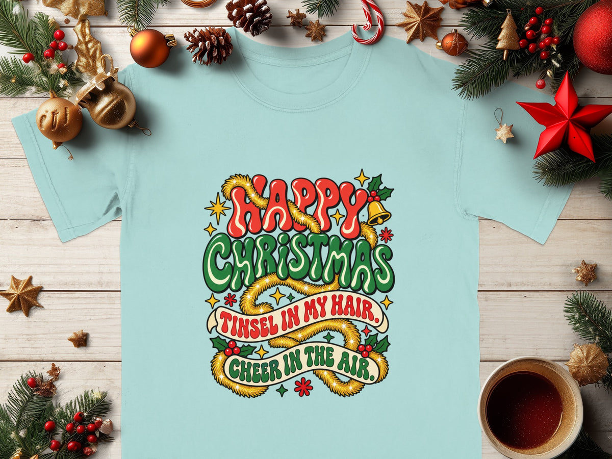 Light blue t-shirt with "Happy Christmas" and "Tinsel in my hair, cheer in the air" text.