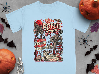 Light blue t-shirt with Cryptid Rodeo graphic featuring Mothman, Bigfoot, UFO, and other creatures.