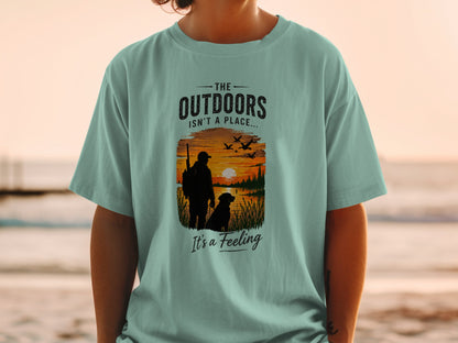T-shirt graphic with text "The Outdoors Isn't a Place... It's a Feeling".