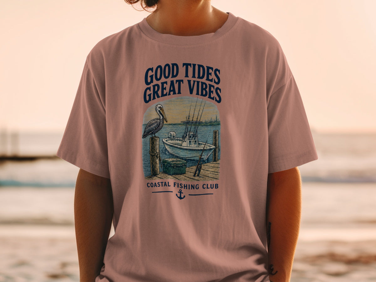 Graphic on pink shirt: "Good Tides Great Vibes" with pelican, boat, and "Coastal Fishing Club".