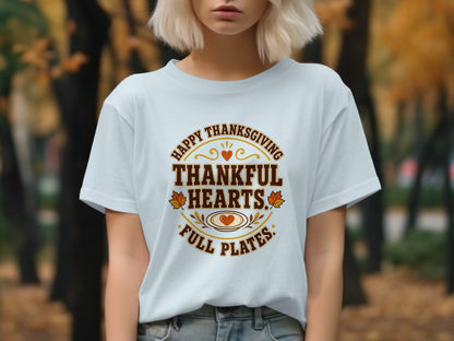 White t-shirt with "Happy Thanksgiving Thankful Hearts Full Plates" text and autumn graphics.