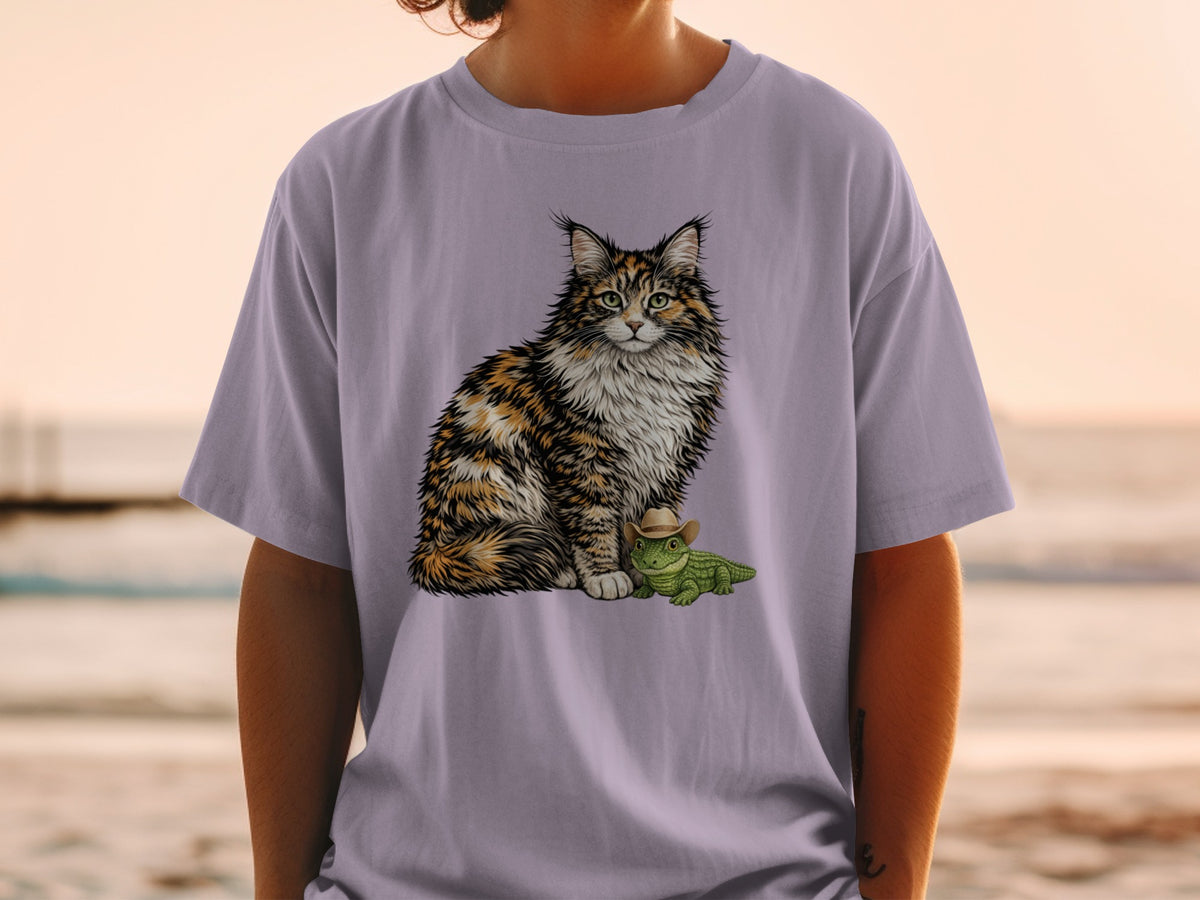 A person wears a light purple t-shirt featuring an illustration of a fluffy calico cat sitting beside a tiny alligator wearing a cowboy hat.