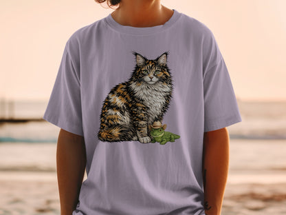 A person wears a light purple t-shirt featuring an illustration of a fluffy calico cat sitting beside a tiny alligator wearing a cowboy hat.
