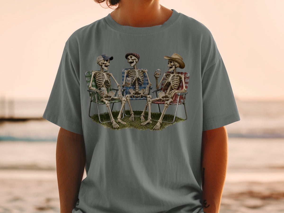 Three skeletons sit in lawn chairs with drinks, wearing hats.