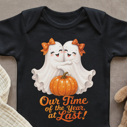Two ghosts with orange bows hug over a pumpkin with text "Our Time of the Year, at Last!".