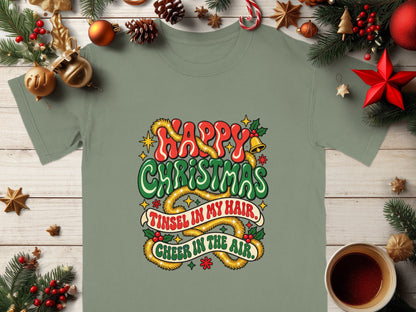 Green t-shirt with "Happy Christmas Tinsel in my hair, Cheer in the air" graphic.