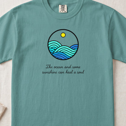 Teal t-shirt featuring a circular ocean graphic and the text The ocean and some sunshine can heal a soul.