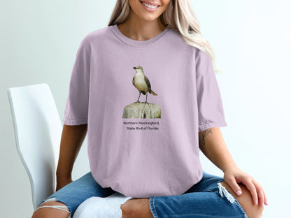 Northern Mockingbird, State Bird of Florida graphic on a lilac t-shirt.
