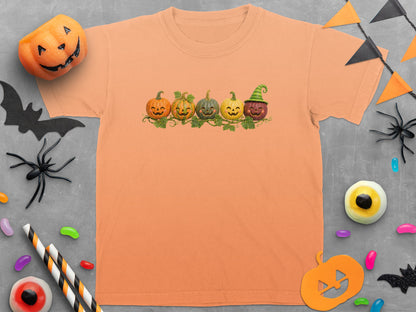 Orange t-shirt with five smiling pumpkins and festive Halloween decorations.