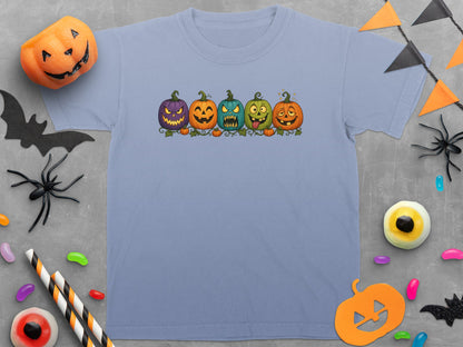 Light blue t-shirt with five cartoon pumpkins and Halloween decorations.