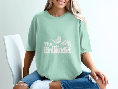 Mint green t-shirt with "The BirdWatcher" text, a bird, and binoculars graphic.