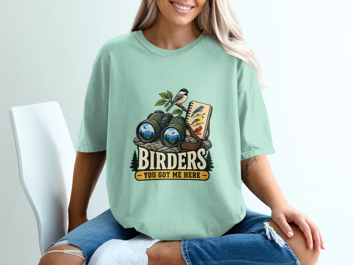 Graphic tee with binoculars, birds, and text "BIRDERS YOU GOT ME HERE".