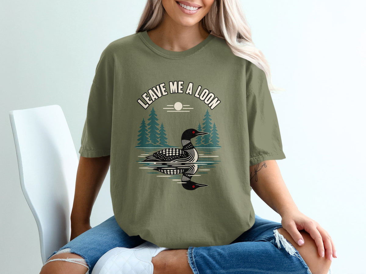 Green t-shirt with "LEAVE ME A LOON" text and loon graphic over water.
