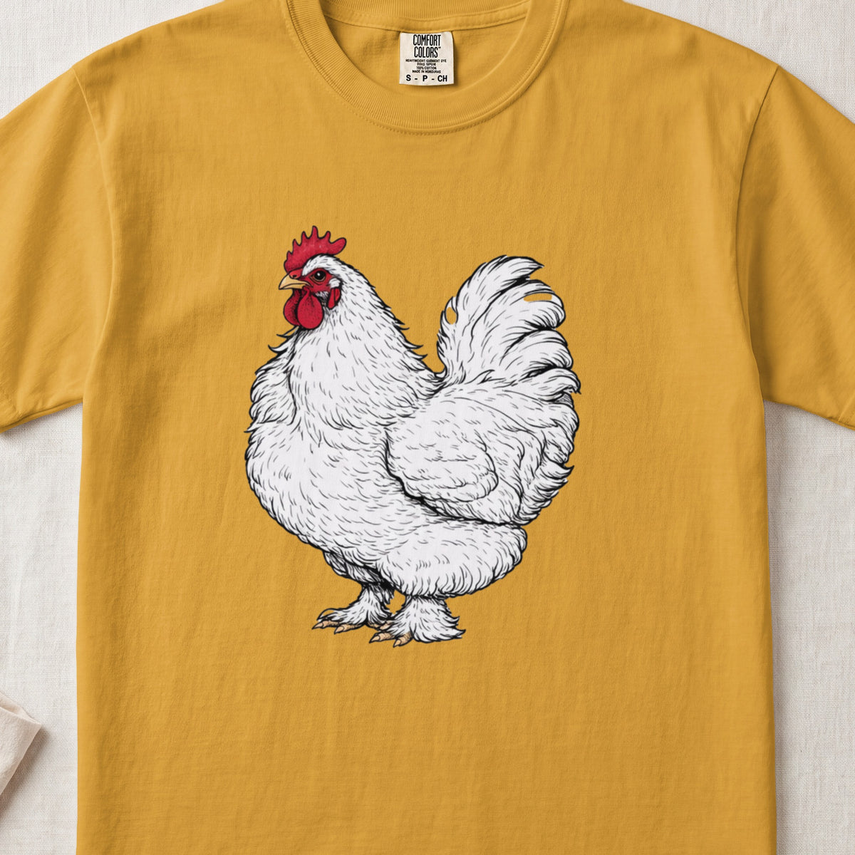 A mustard yellow short-sleeve t-shirt featuring an illustration of a white rooster on the chest.