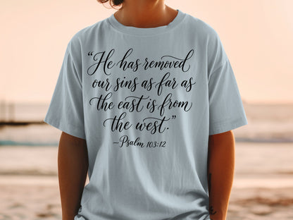 Light blue t-shirt with "He has removed our sins as far as the east is from the west. -Psalm 103:12" in black script.