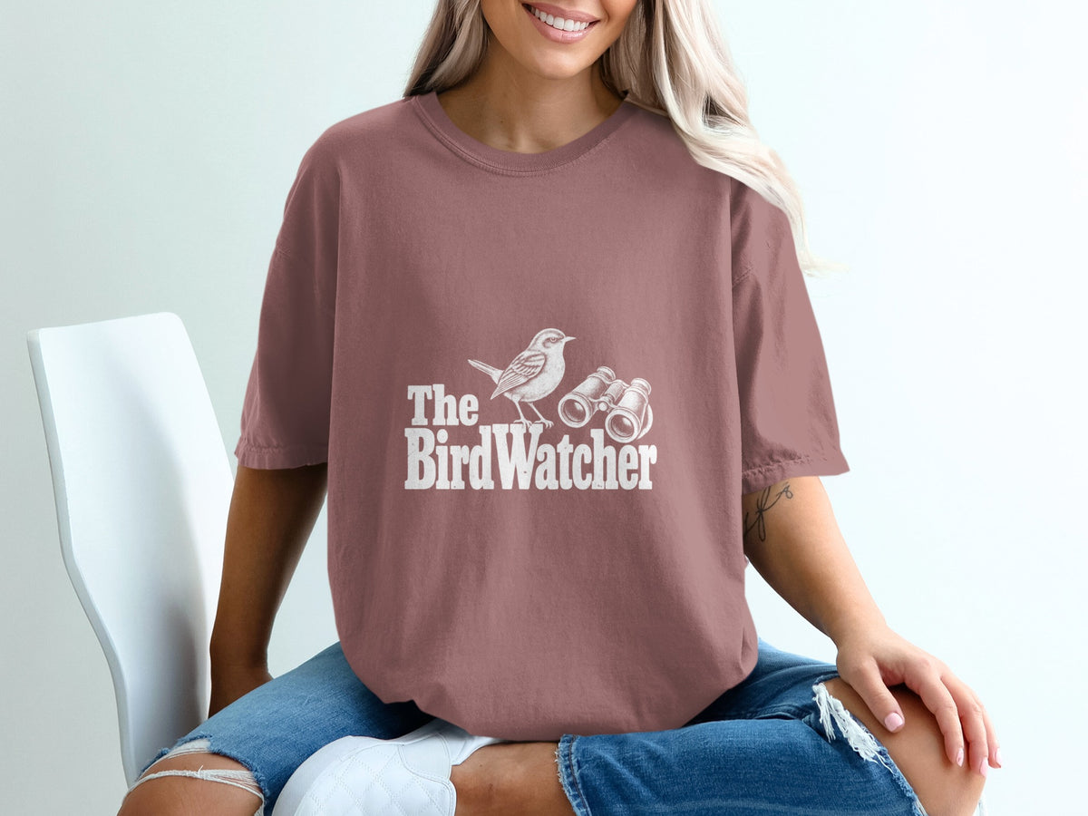 Brown t-shirt with white text and graphics: a bird and binoculars.