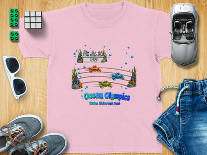 Pink t-shirt with "Ocean Olympics 100m Sideways Dash" cartoon graphic.