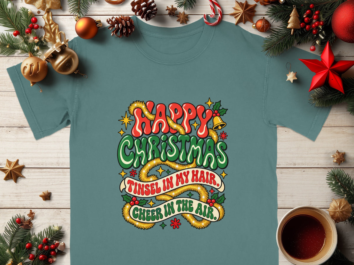 Teal t-shirt with "Happy Christmas" and "Tinsel in my hair. Cheer in the air." holiday graphic.
