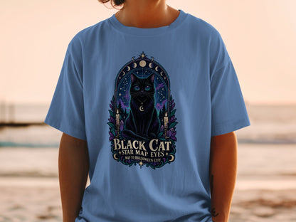 Black cat with star map eyes graphic on a blue t-shirt with text.