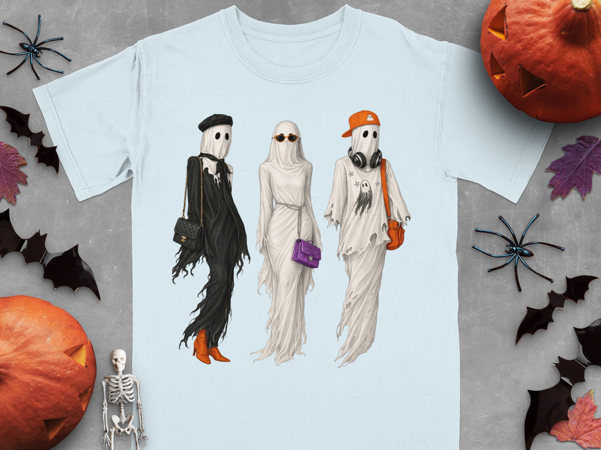 Three ghosts in fashionable outfits and accessories stand on a light blue t-shirt.