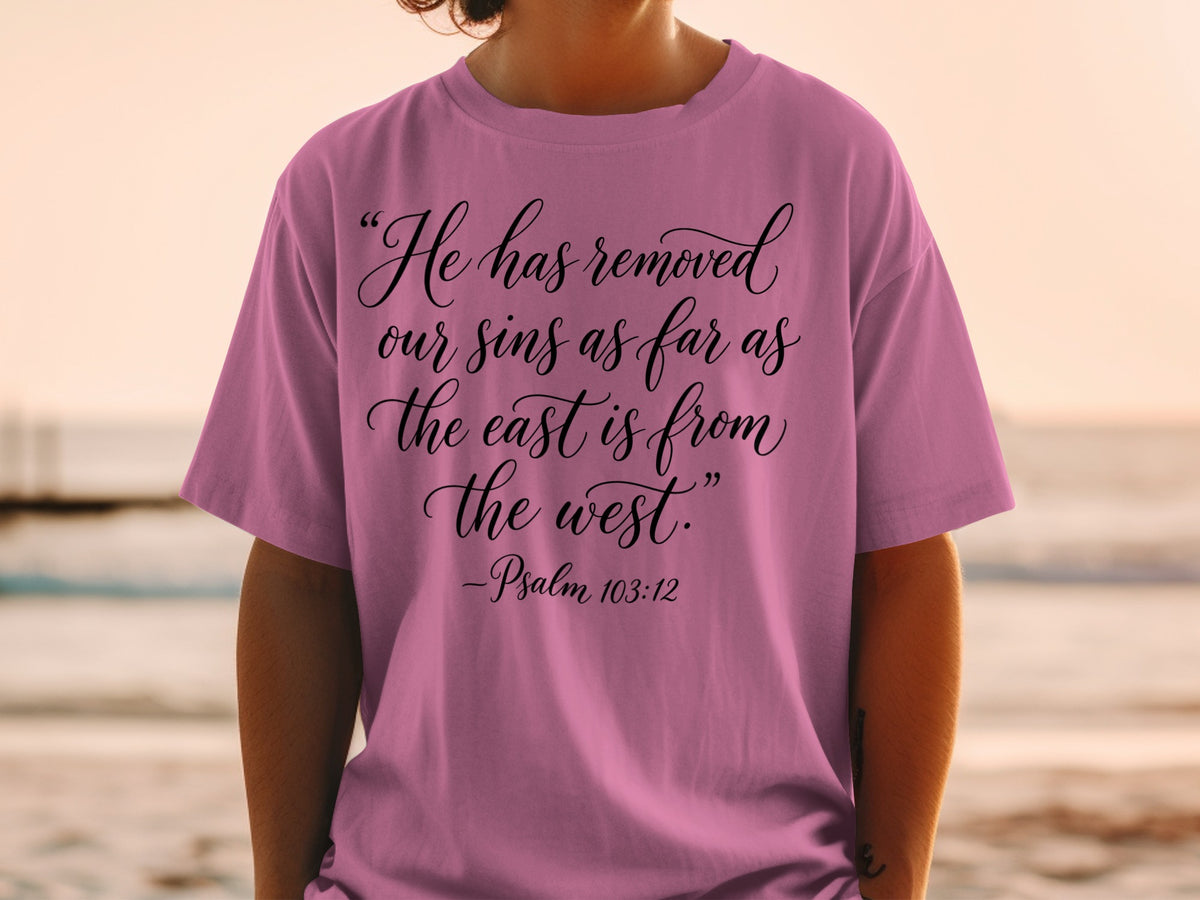 Pink t-shirt with text "He has removed our sins as far as the east is from the west. -Psalm 103:12".
