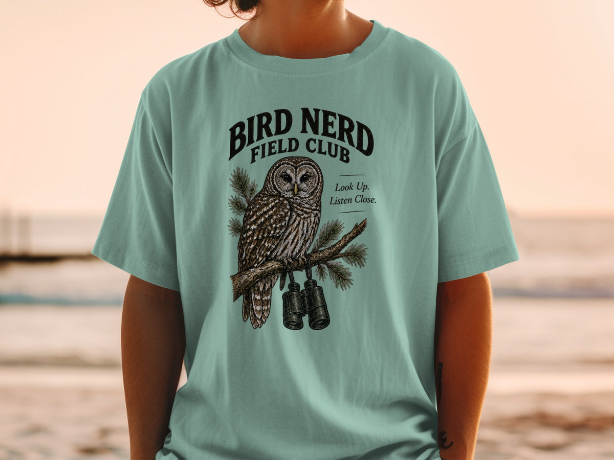 T-shirt graphic with owl, binoculars, and text "BIRD NERD FIELD CLUB".