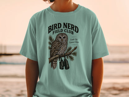 T-shirt graphic with owl, binoculars, and text "BIRD NERD FIELD CLUB".