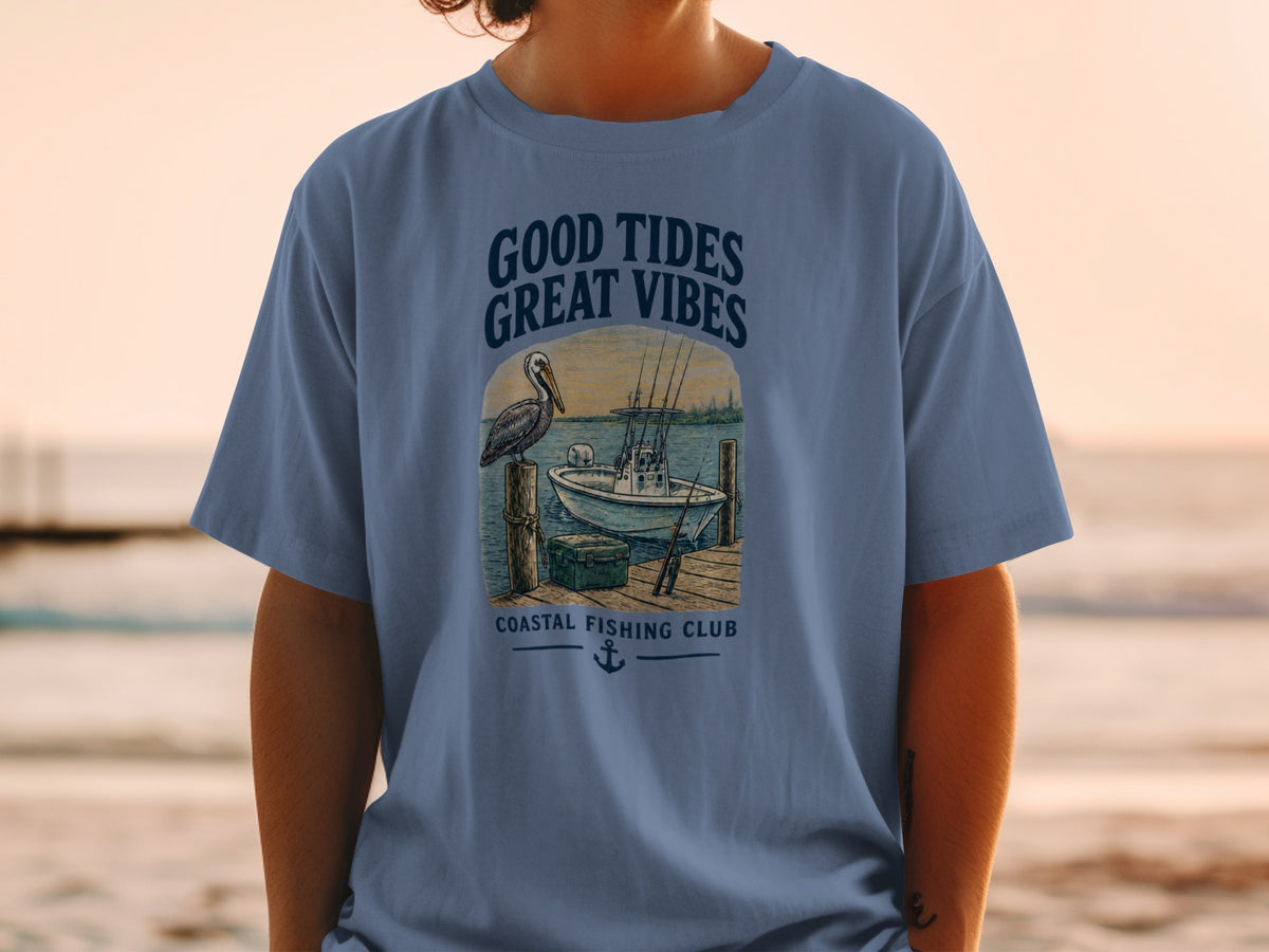 Blue t-shirt graphic with text "Good Tides Great Vibes" and fishing scene.