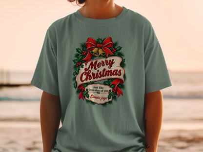 Green t-shirt with a "Merry Christmas" design featuring bells, holly, and ribbon.