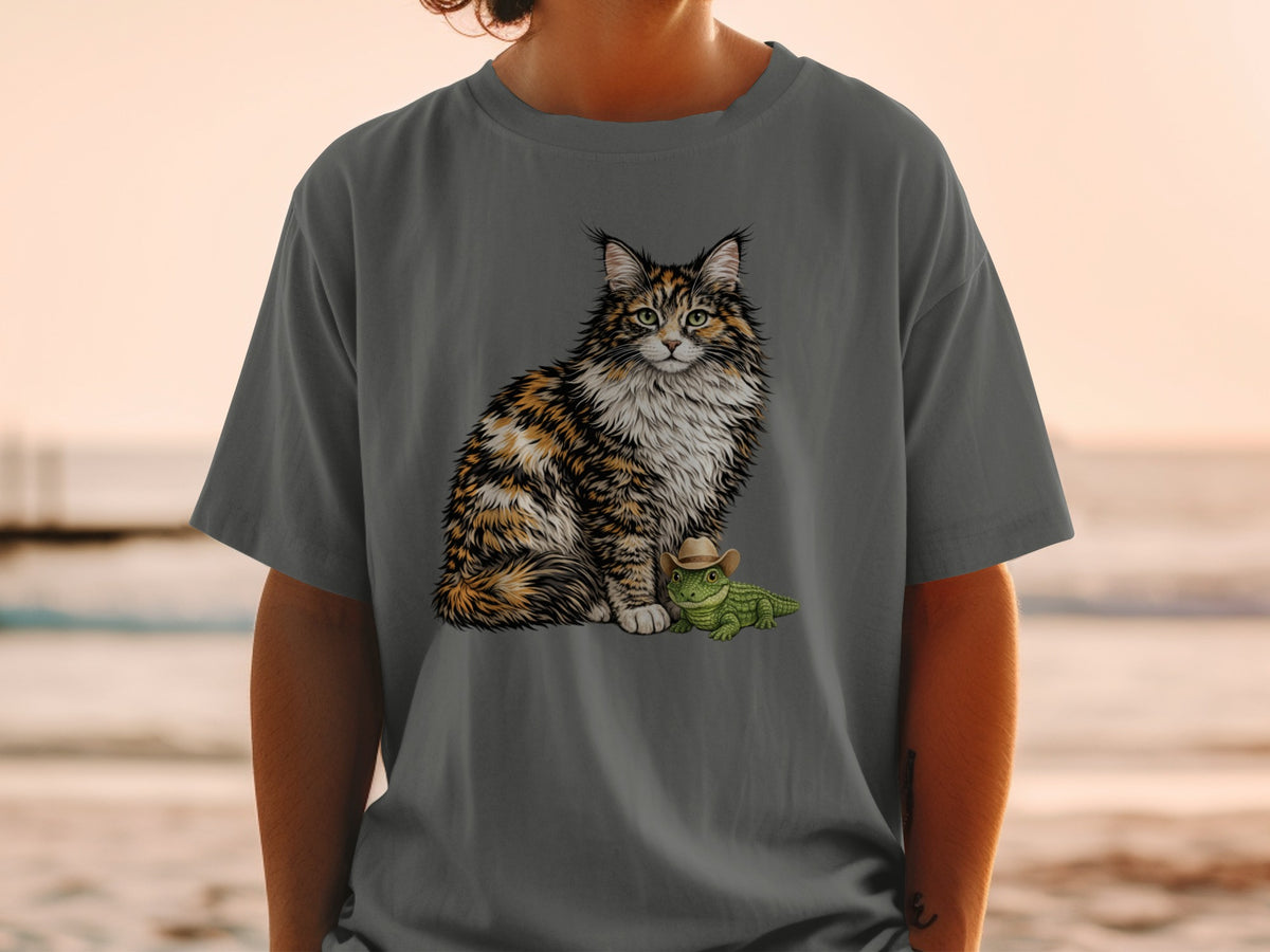 A person wearing a grey t-shirt printed with a fluffy calico cat sitting beside a small alligator wearing a cowboy hat.