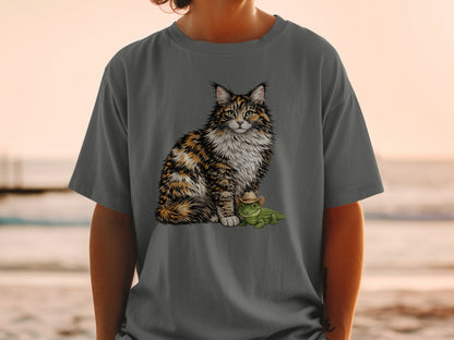 A person wearing a grey t-shirt printed with a fluffy calico cat sitting beside a small alligator wearing a cowboy hat.