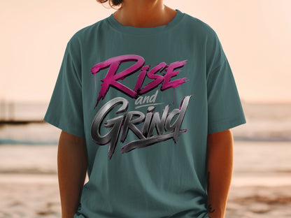 Teal t-shirt with metallic pink and silver "Rise and Grind" text graphic.