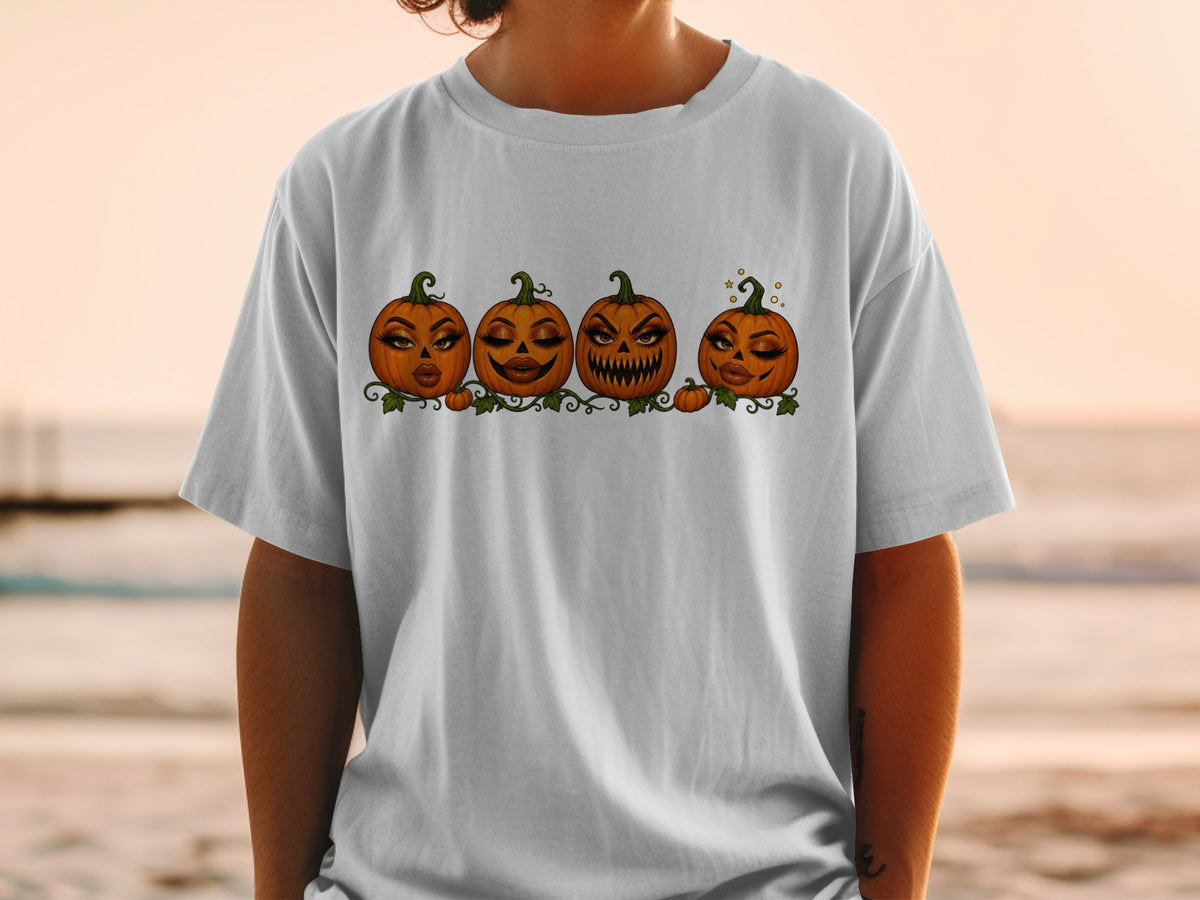 Four Halloween pumpkins with makeup and leafy vines on a white t-shirt.