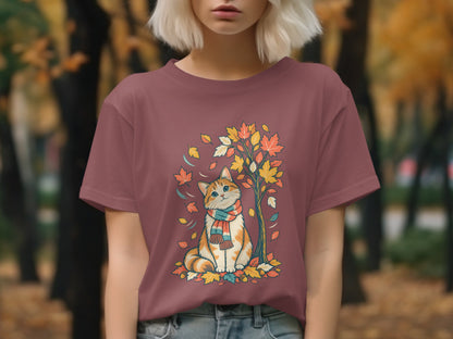 T-shirt with cartoon cat wearing scarf under autumn tree and falling leaves.