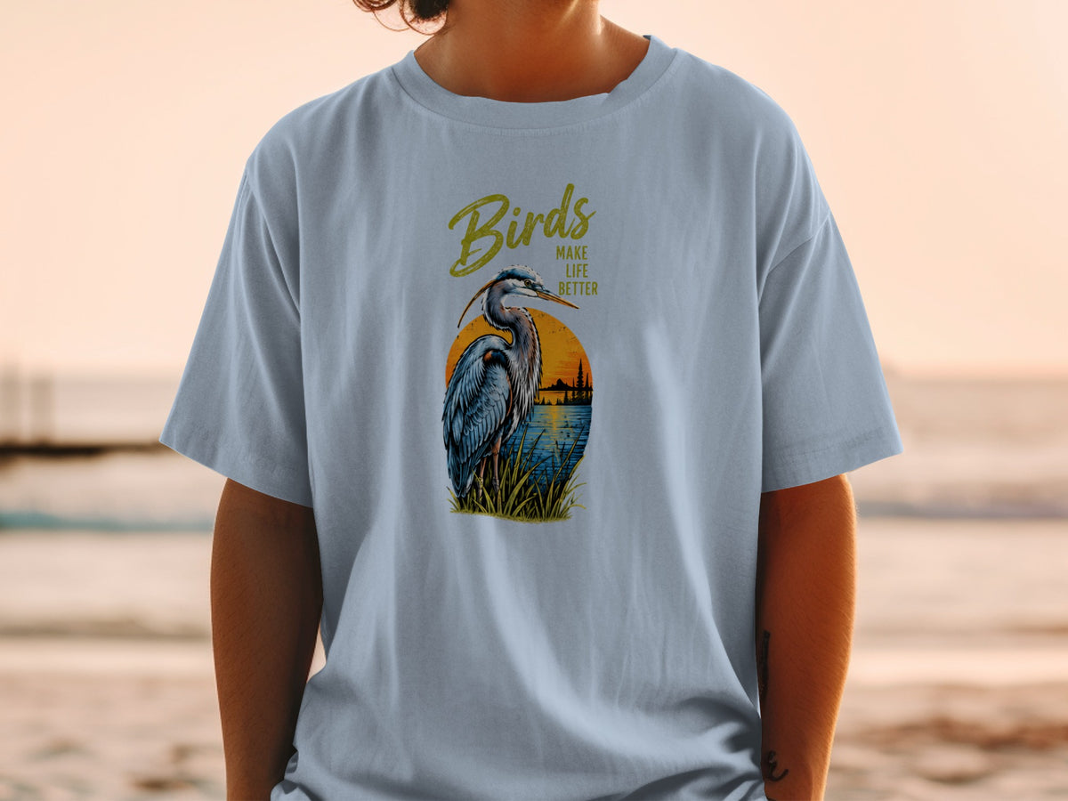 Heron at sunset graphic with text "Birds Make Life Better" on a blue shirt.
