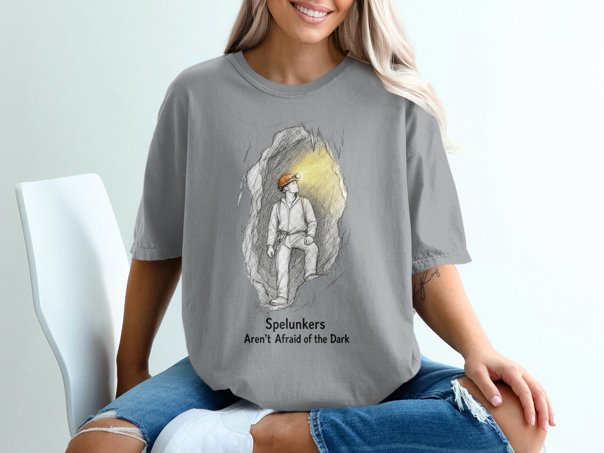 T-shirt graphic of a spelunker in a cave with text "Spelunkers Aren't Afraid of the Dark".